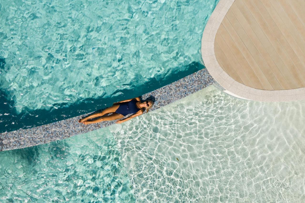 Crystalbrook Riley Cairns Exterior foto Aerial view of a woman sunbathing in a swimming pool